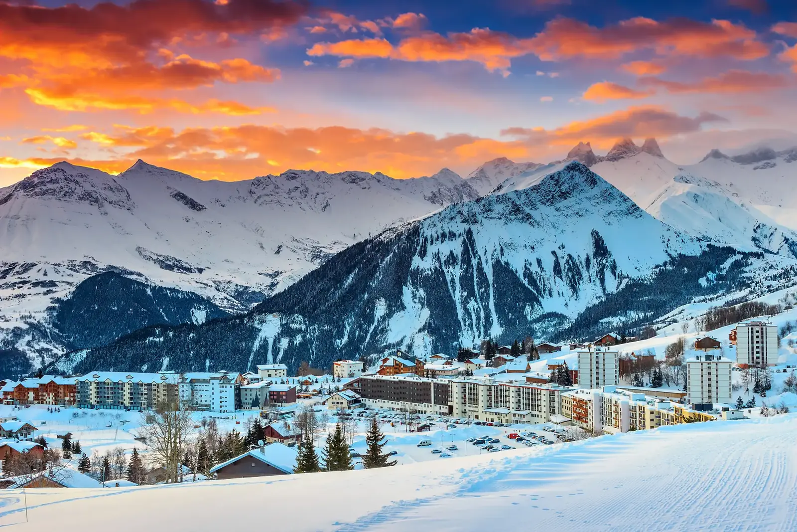 La station de La Toussuire sous la neige au coucher du soleil, face aux sommets des Sybelles en Maurienne