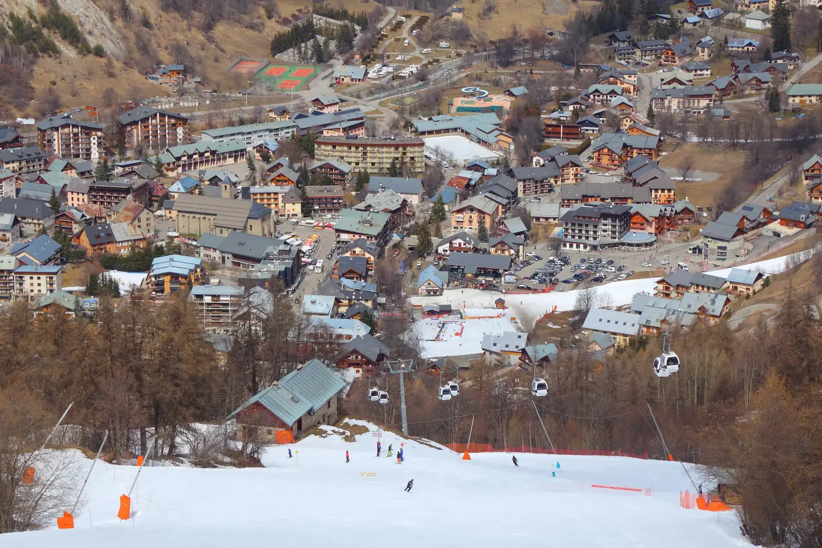Le village de Valloire vu d'en haut en fin d'hiver, avec sa piste de ski et sa télécabine au cœur de la station